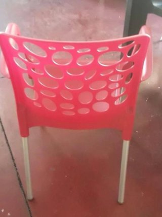 Sillas de plástico rojas con patas plateadas