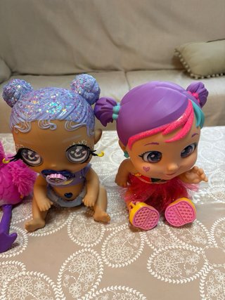 Cuna de muñecas rosa con muñecas/os.