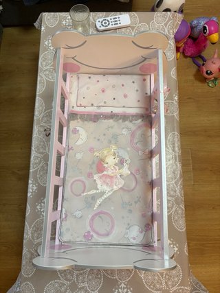 Cuna de muñecas rosa con muñecas/os.