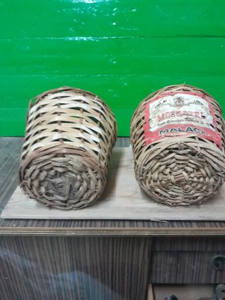 Due vecchie bottiglie di vetro con vimini
