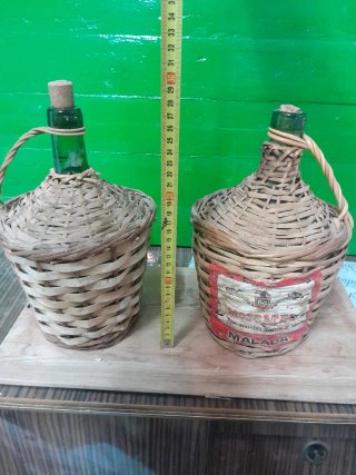 Due vecchie bottiglie di vetro con vimini