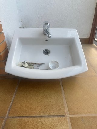 Lavabo de cerámica con grifo metálico empotrado
