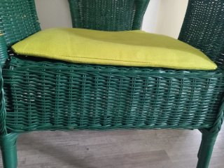 Sillón de mimbre verde con cojín amarillo