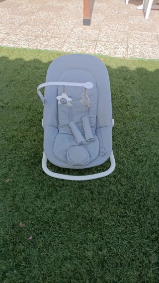Hamaca bebé gris con arco de juegos.