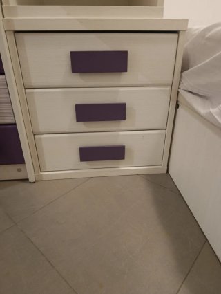 Mesita de noche blanca con cajones morados