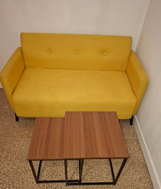 Sofá amarillo y mesas de centro
