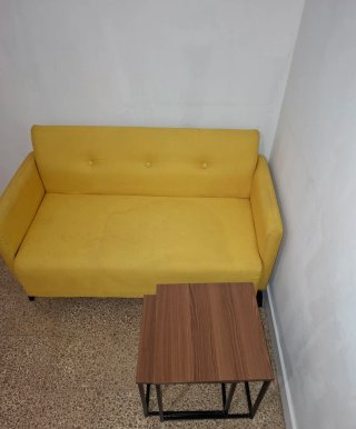 Sofá amarillo y mesas de centro