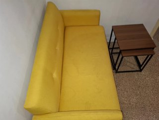Sofá amarillo y mesas de centro