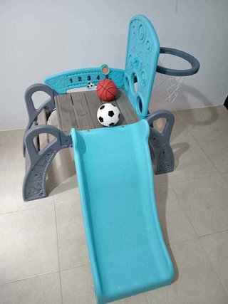 Parque infantil con tobogán y canasta