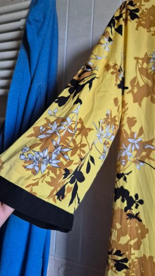 Kimono lungo con stampa floreale su fondo giallo.