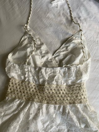 Vestido blanco corto con detalles dorados.