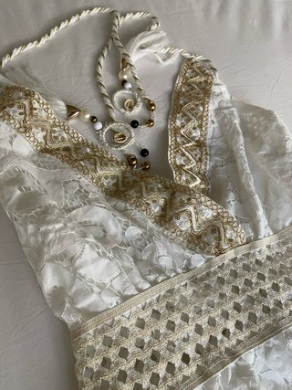 Vestido blanco corto con detalles dorados.