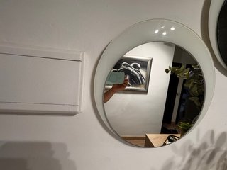 Recibidor blanco y gris con dos espejos.