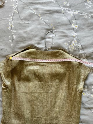 Chaleco dorado con cremallera y volantes