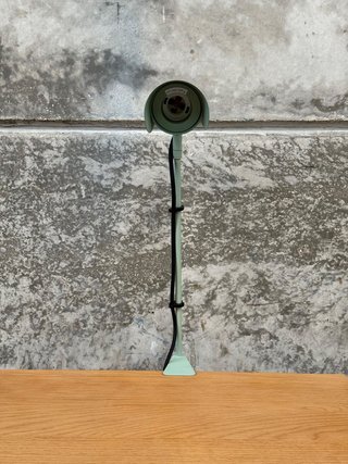 Lámpara de escritorio con pinza Jula de metal verde.