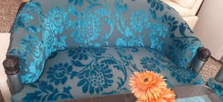 Sofá de tela azul con mesa de cristal y lampara pi