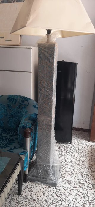 Sofá de tela azul con mesa de cristal y lampara pi