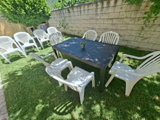 Mesa de jardín y 10 sillas de plástico.
