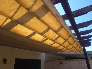 Pérgola de madera con toldo beige