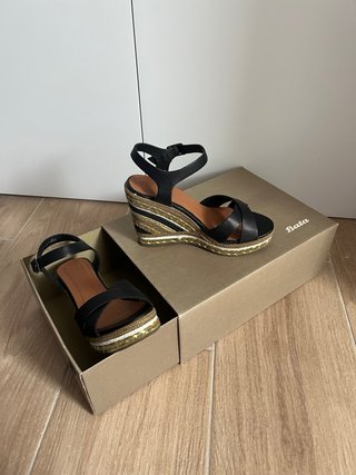 Sandalias de cuña negras y doradas.