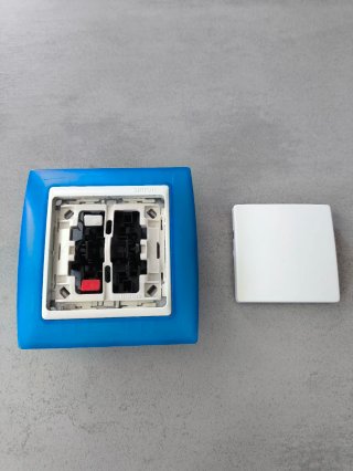 Interruptor de pared con marco azul marca simon