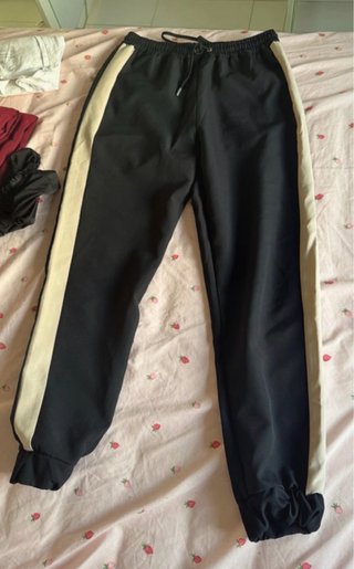 Pantalones deportivos negros con banda lateral