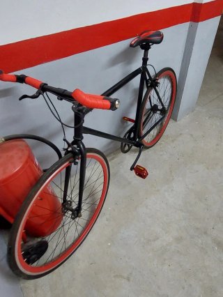 Bicicleta urbana negra con detalles rojos