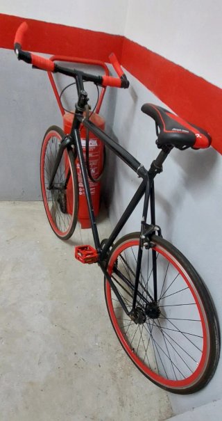 Bicicleta urbana negra con detalles rojos
