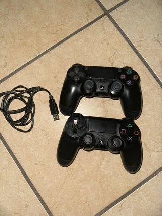 Ps4 Slim Nera insieme a 2 controller e 4 giochi