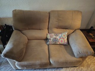 Sofá de tela beige con cojín estampado