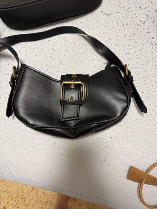 Bolso negro con hebilla dorada