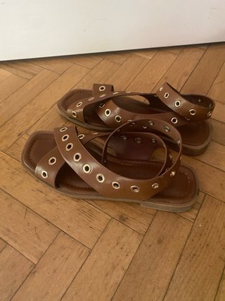 Sandalias romanas piel marrón ojales dorados