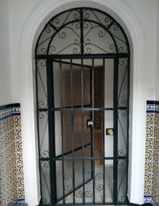 Puerta de entrada con reja y cerradura