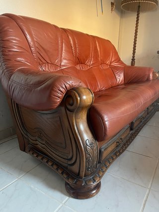 Sofá de cuero marrón con detalles de madera