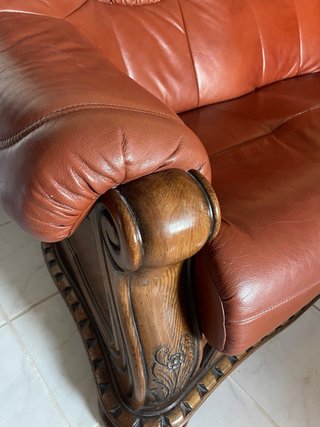 Sofá de cuero marrón con detalles de madera