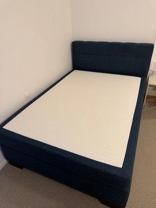 Cama azul con cabecero tapizado