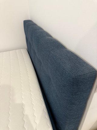 Cama azul con cabecero tapizado