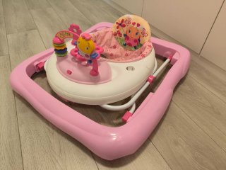 Andador de bebé rosa con juguetes