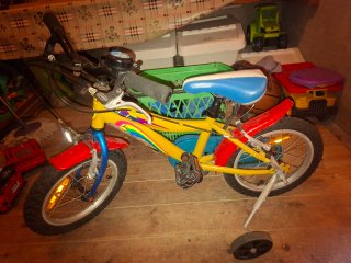Bicicleta infantil amarilla con ruedas de colores