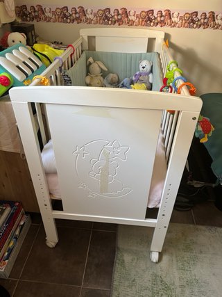 Cuna de bebé blanca con juguetes