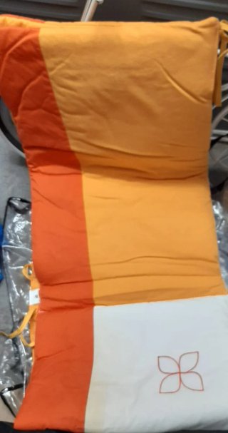 Protector de cuna naranja y blanco