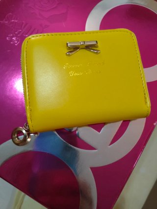 Cartera amarilla con lazo y texto