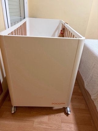 Cuna de bebé blanca con ruedas