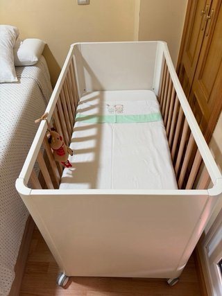 Cuna de bebé blanca con ruedas