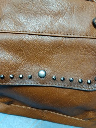 Bolso marrón con tachuelas plateadas.