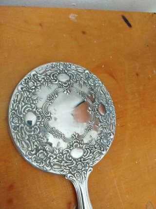Espejo de mano antiguo con marco decorado