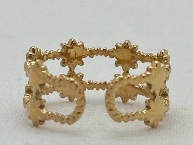 Anillo de acero inoxidable dorado con estrellas.