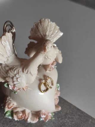 Figuras de palomas de resina sobre corazón