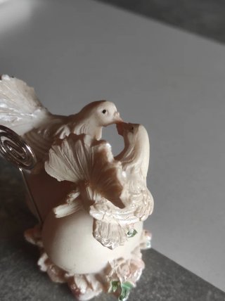 Figuras de palomas de resina sobre corazón