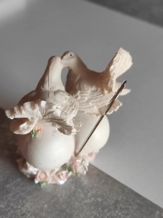 Figuras de palomas de resina sobre corazón
